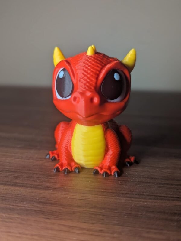 Mini dragefigur i 3D-printet PLA med detaljerte vinger, stående på underlag